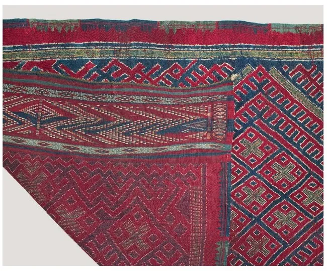 Close-up of the rug's richly patterned red-and-blue kilim end