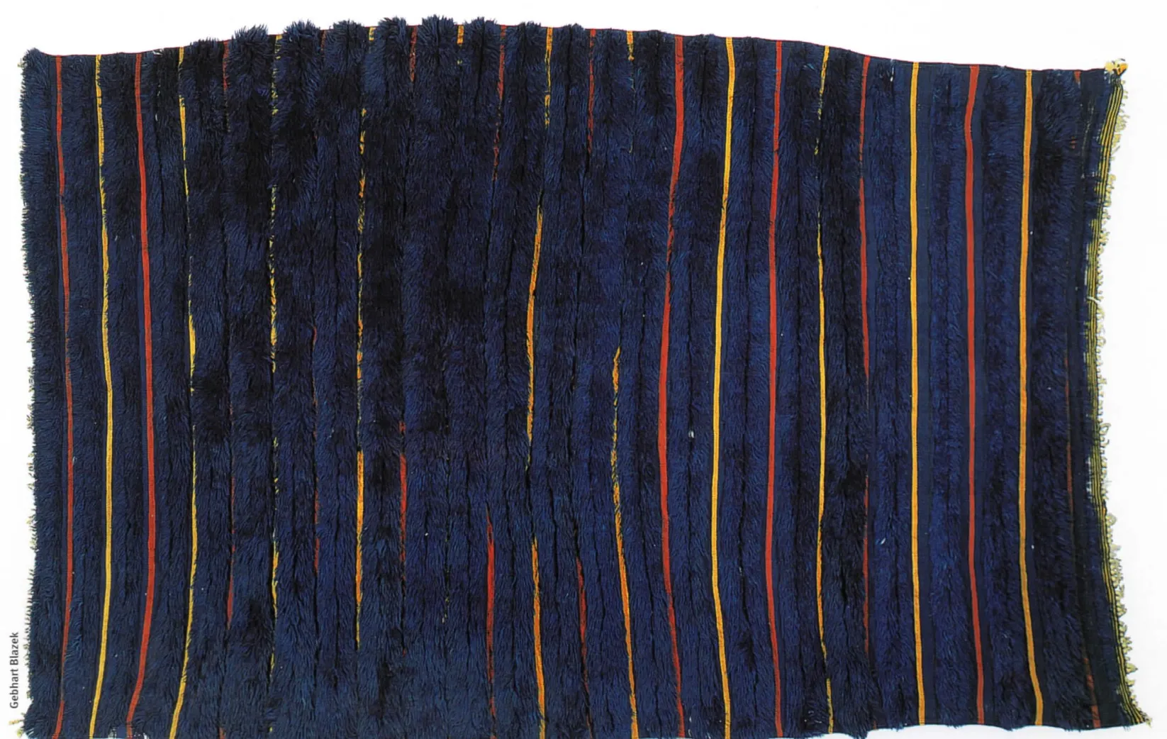 Dark blue piled shawl punctuated by narrow orange and red stripes