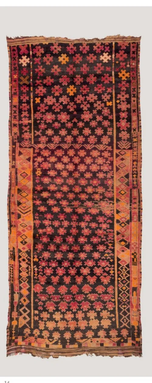 Long dark rug covered with small multicoloured geometric motifs