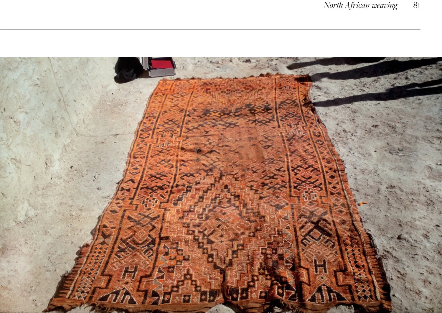 Large orange Beni Snassen rug laid out on the ground