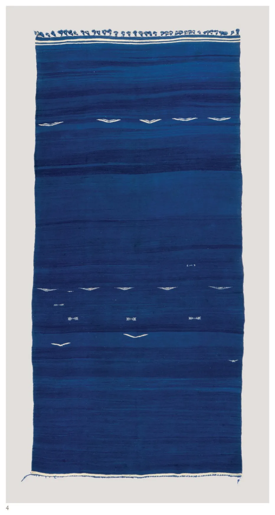 Indigo flatweave with subtle tonal bands and small white marks